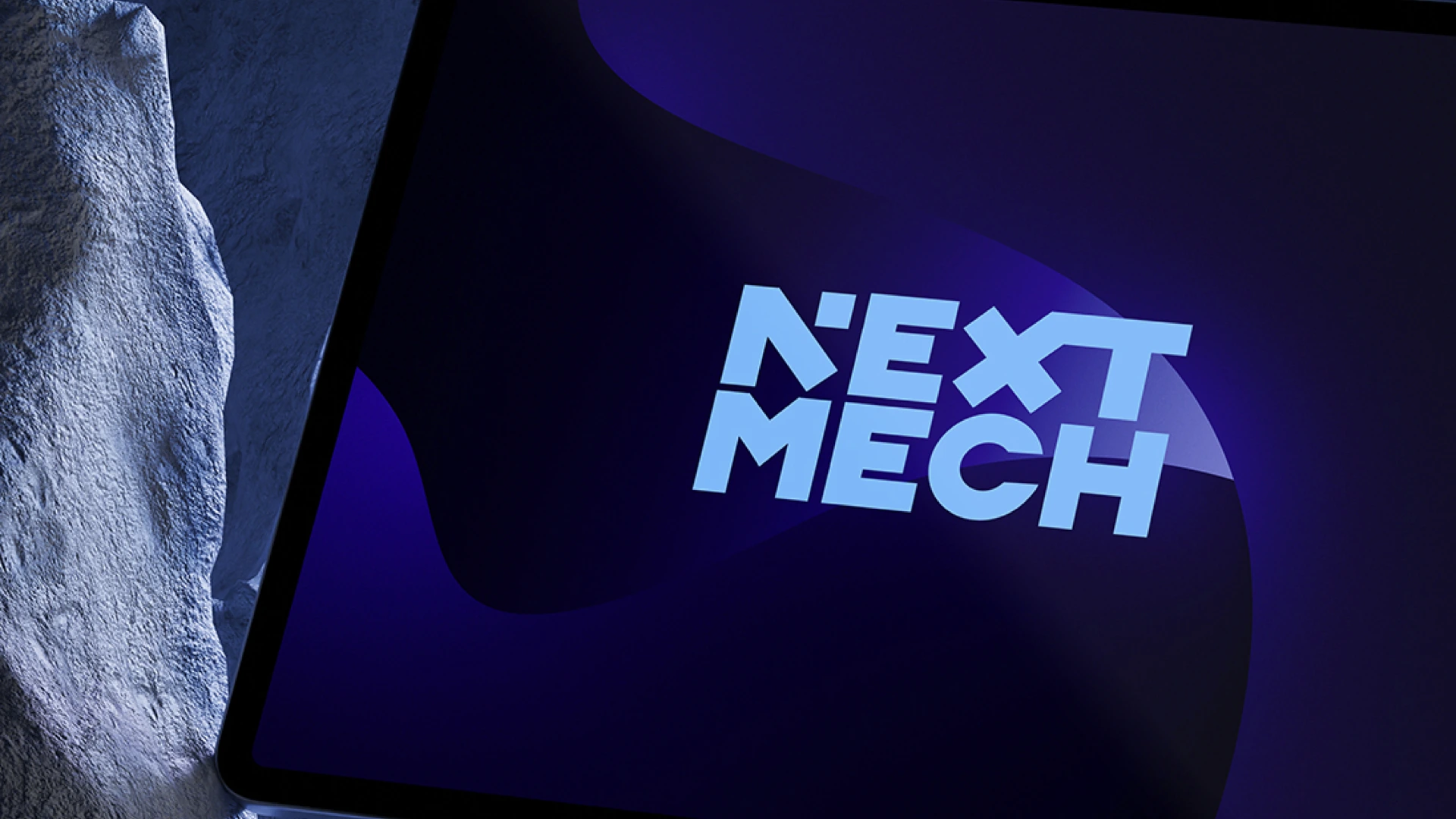 NEXT MECHs logotyp på en surfplatta.