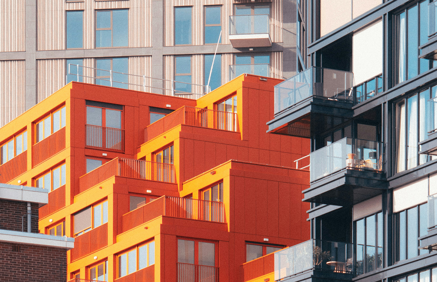 Flerbostadshus med orange fasader och balkonger.