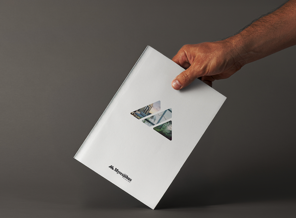 Myresjöhus katalog med vit omslagsdesign, hållen i en hand