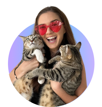 Woman in red shades smiling holding her two cats