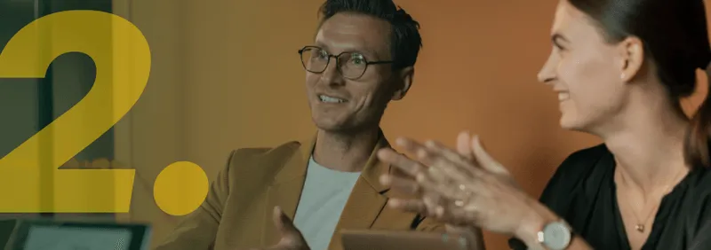 Twee collega's lachen en communiceren tijdens een vergadering op kantoor