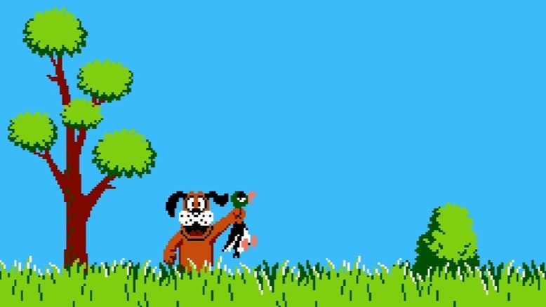 Pixelated dog happily holding a duck in tall grass with a tree and blue sky background.