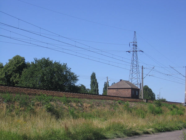 Photo of railroad tracks under power lines.