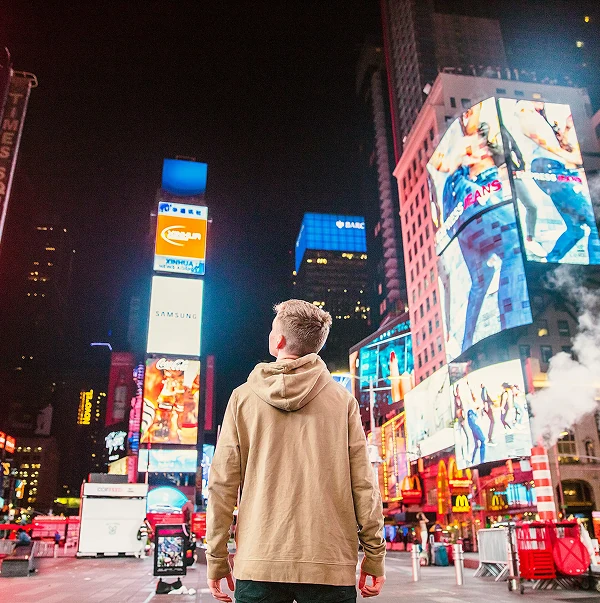 Bright digital billboards in a city square at night, linking media campaigns to measurable brand outcomes.