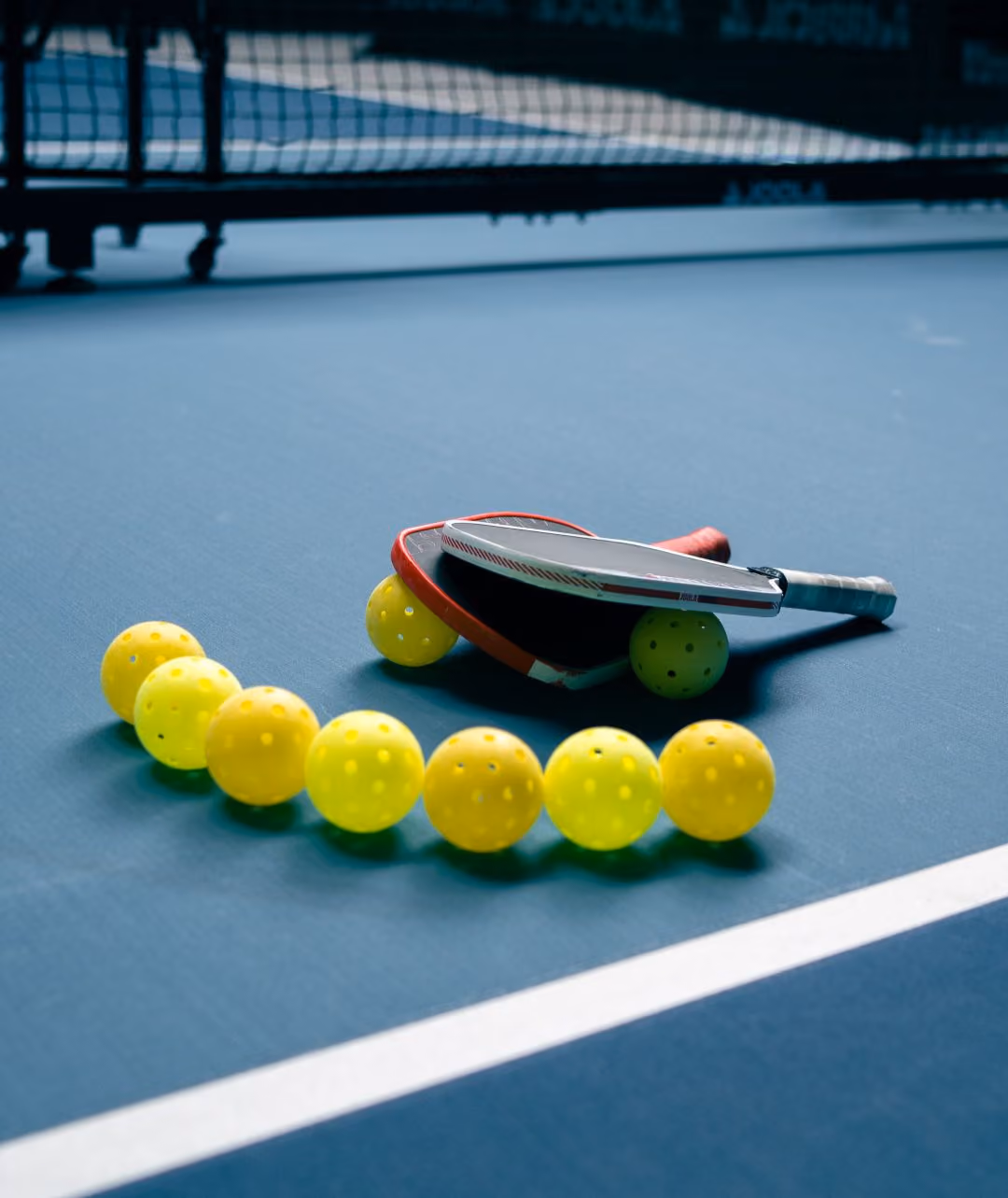 Pickleball Paddles mit Bällen auf Court