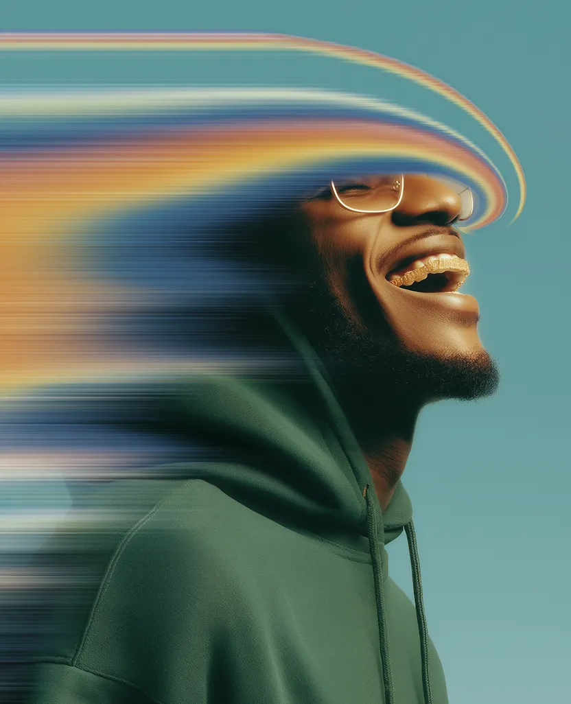 Smiling man wearing glasses and hoodie with colorful motion blur around his head.