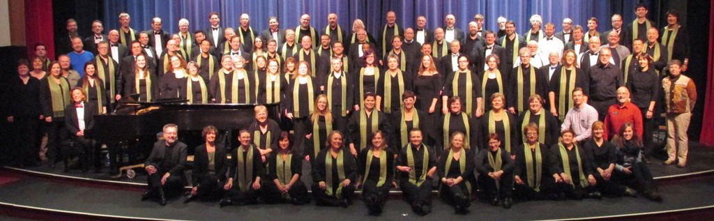 A chorus poses for a picture on a stage