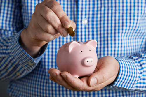 A person puts a coin in a piggy bank