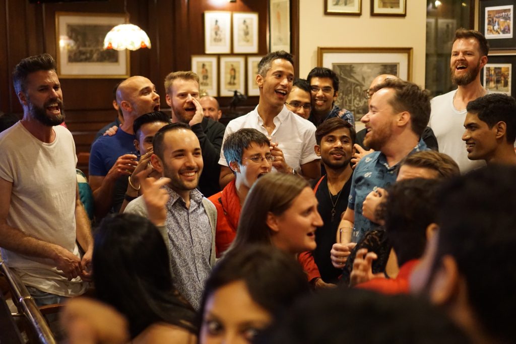 A group of people laugh and watch a performance