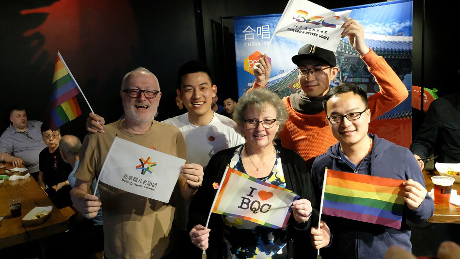 A group of people holding flags pose for a picture
