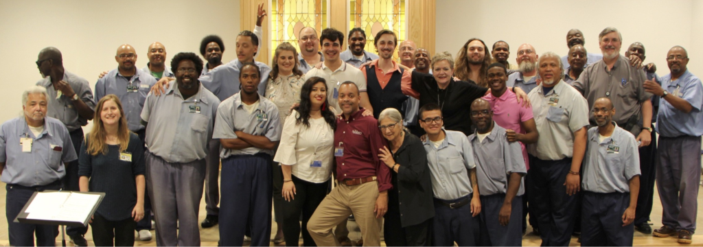 A group of people pose for a picture, several of them dressed in blue
