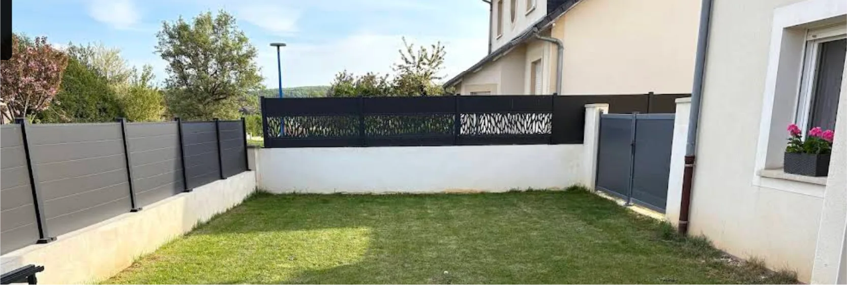Jardin non aménagé avec pelouse abîmée et coin feu délabré, avant travaux