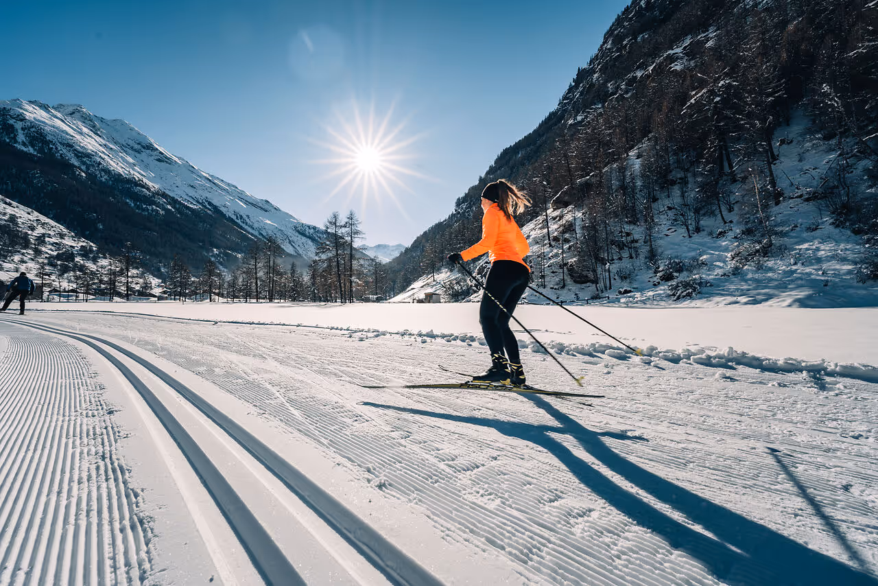 A cross-country skier on the freshly groomed trail near Täsch on a sunny winter day