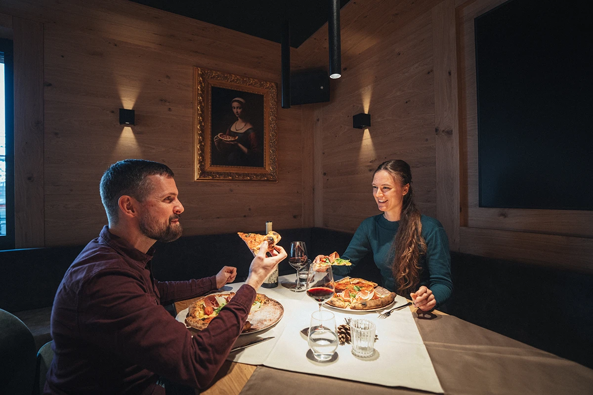 A cozy dinner at DaVinci Täsch restaurant—authentic wood-fired pizza and wine at the Hotel Porta Cervino