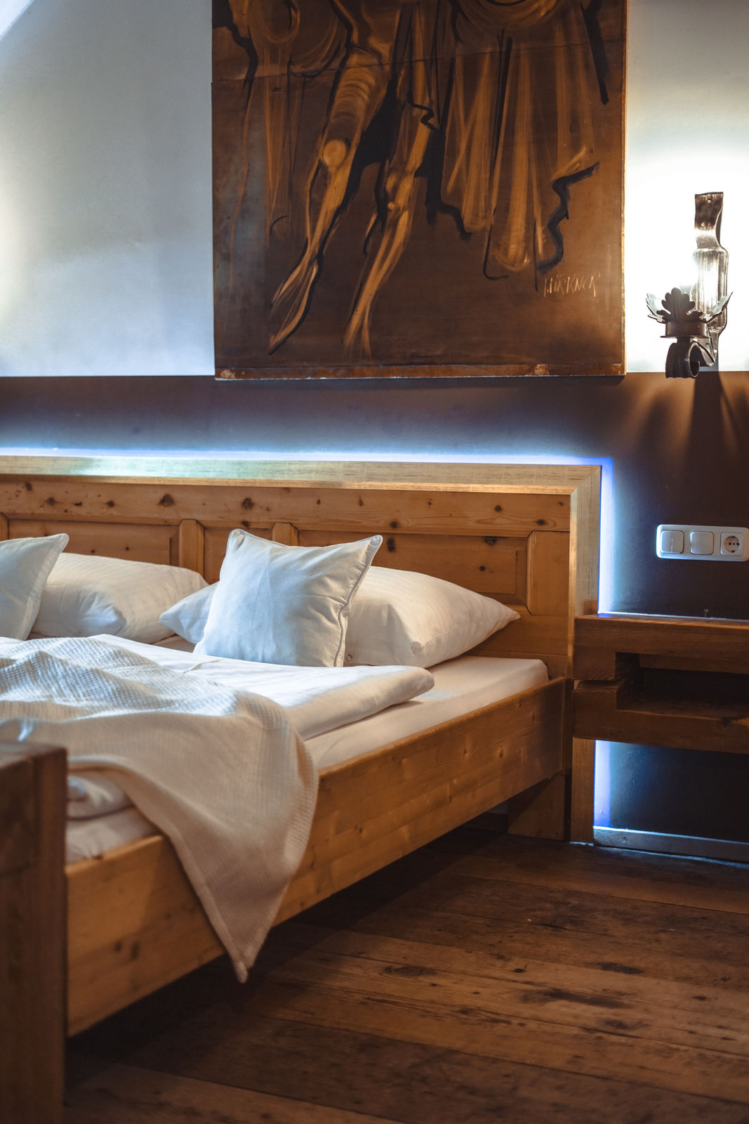 Schlafzimmer im Apartment Bergfried mit historischem Holzbett und Kunstwerk