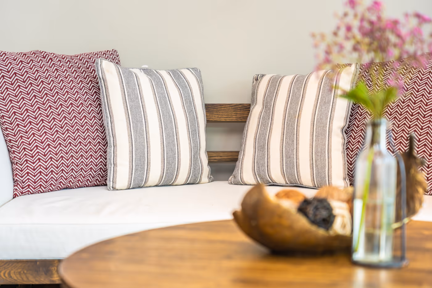 Sofa with pillows and coffee table with flower in vase stock image