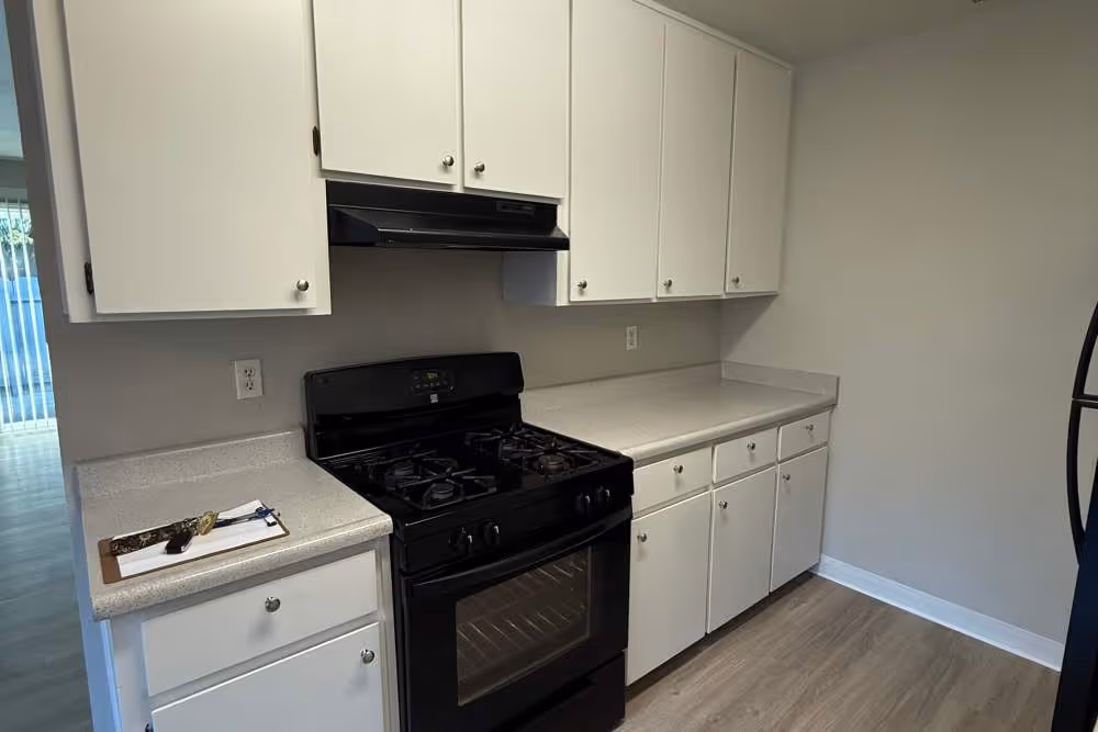 Kitchen with white cabinets and black appliances