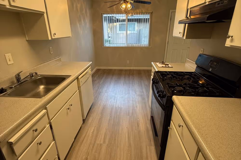 Kitchen with white cabinets and black appliances and view of unfurnished dining area