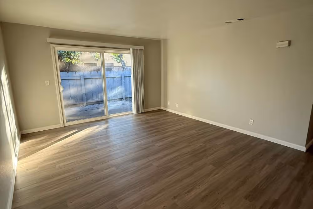 View of unfurnished living area with doors to patio balcony