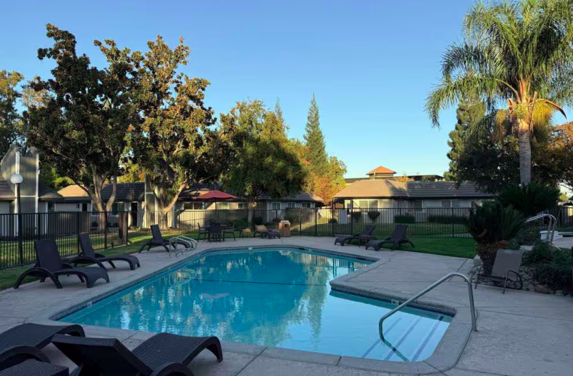 Swimming pool with lounge chairs around it.
