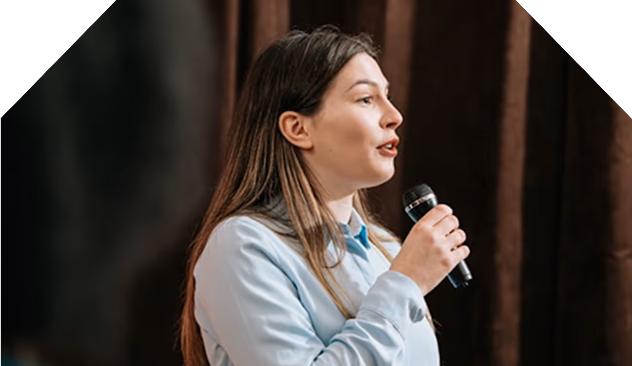 Femme parlant dans un microphone lors d'une présentation ou d'un discours.