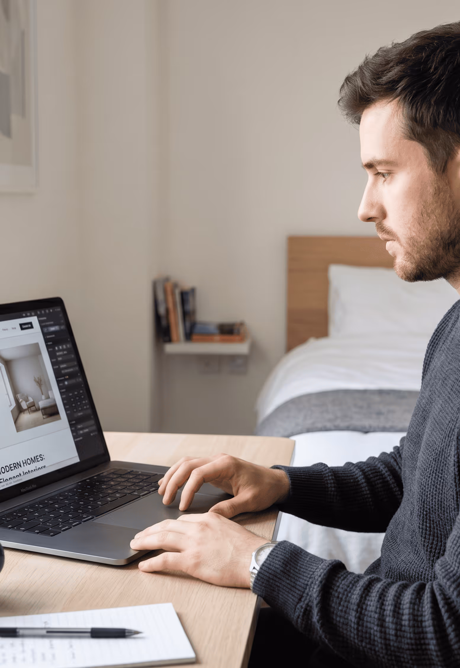 Homme concentré utilisant un ordinateur portable sur un bureau dans une chambre moderne.