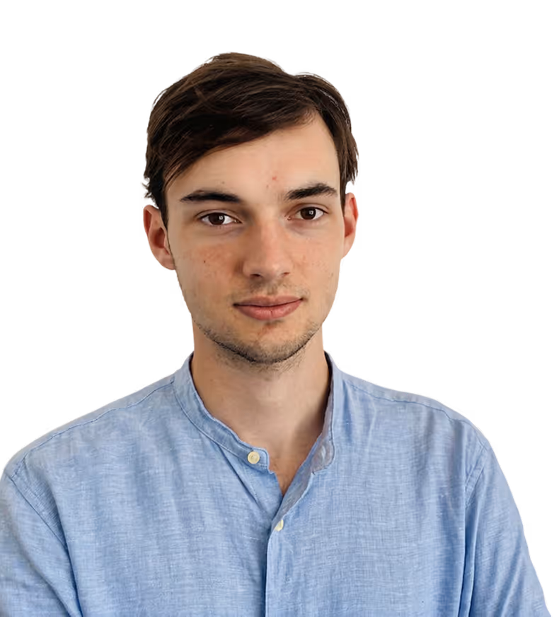 Jeune homme aux cheveux bruns, chemise bleue clair, regardant droit devant, fond noir.
