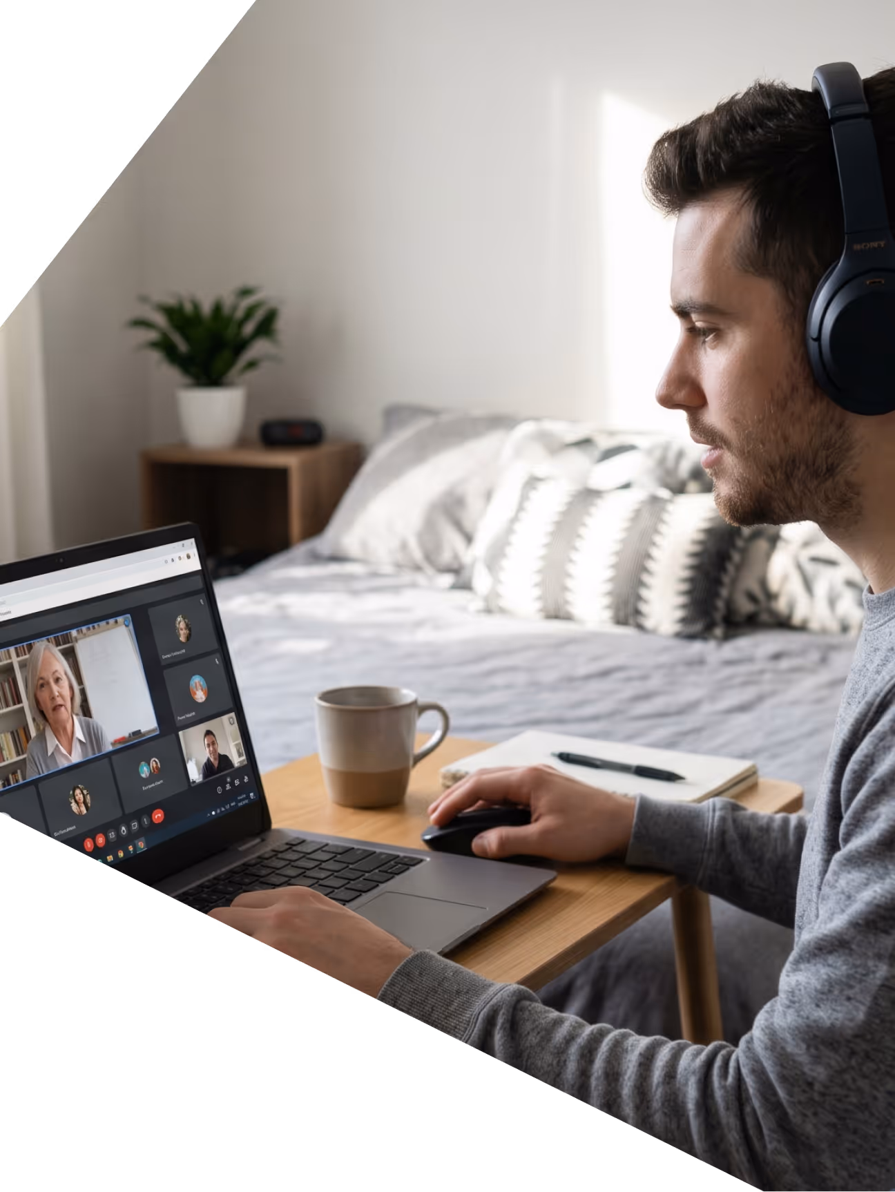 Jeune homme avec casque participe à une visioconférence sur un ordinateur portable dans une chambre
