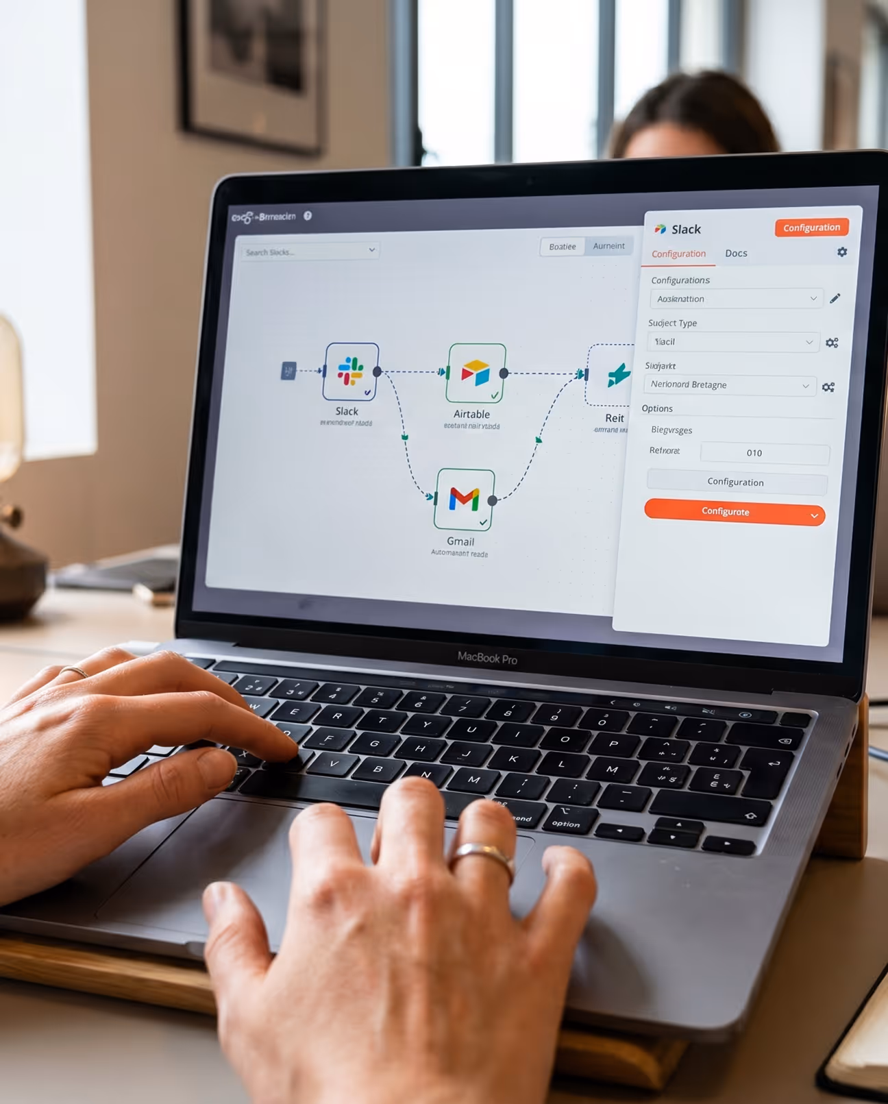 Main sur un MacBook Pro configurant une automatisation reliant Slack, Airtable et Gmail.