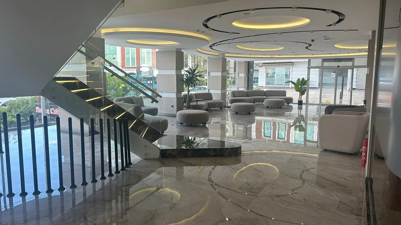 Lobby della clinica Estepalace Istanbul con scala in marmo e lounge