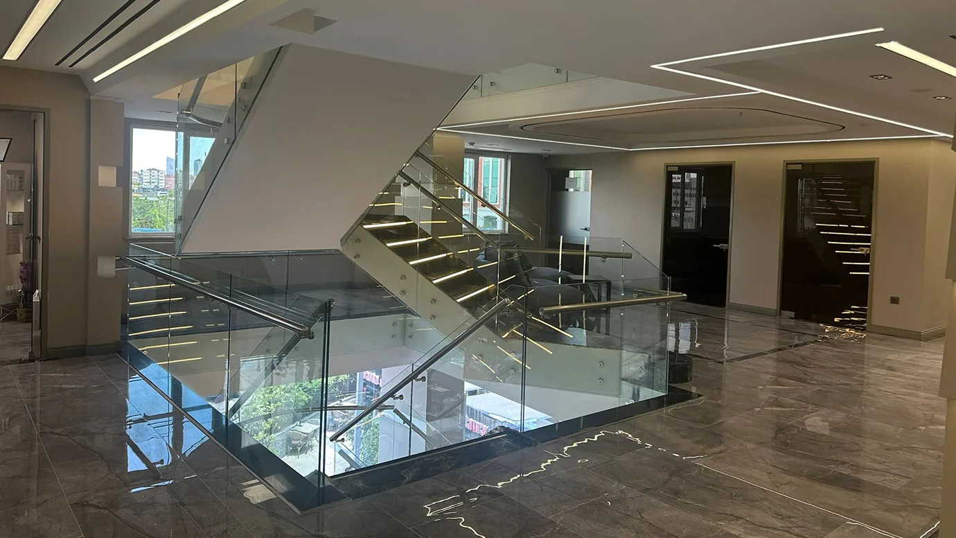 Atrio interno clinica Estepalace Istanbul con scala in vetro e marmo