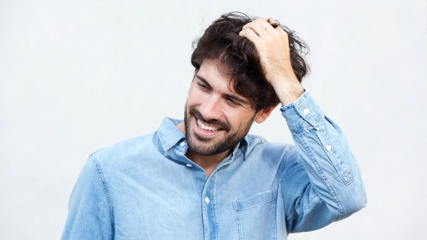Uomo giovane con capelli folti, candidato trapianto capelli
