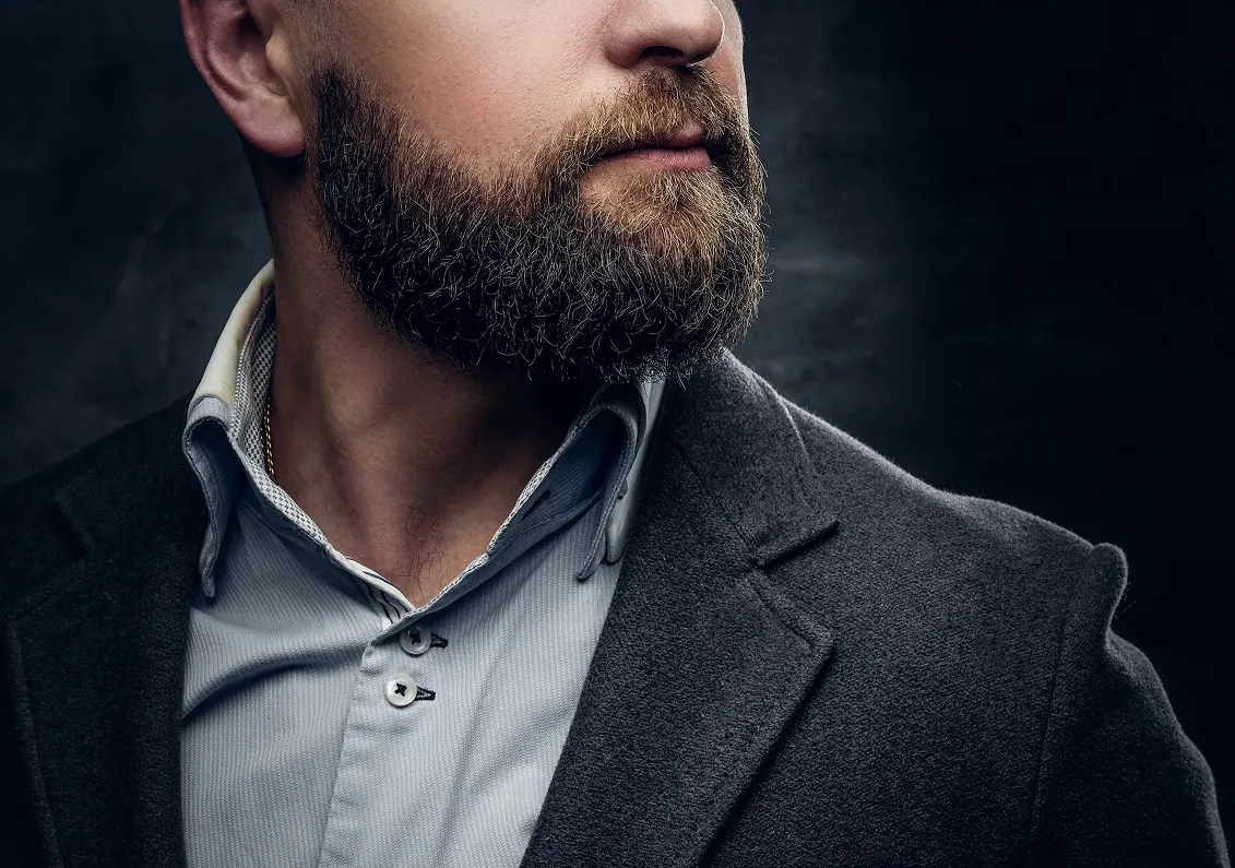 Primo piano di uomo con barba folta e curata