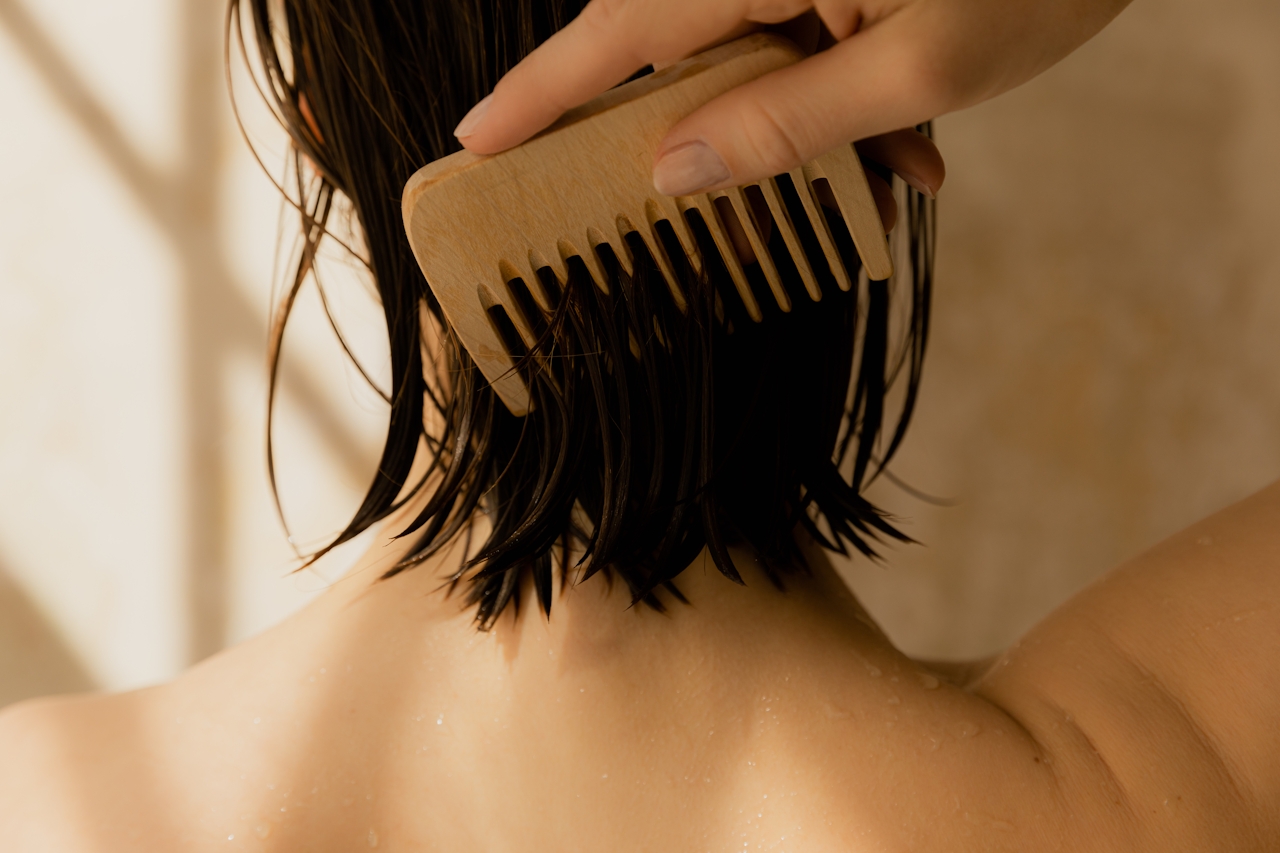 Vrouw die haar hoofdhuid onderzoekt in de spiegel voor tekenen van androgenetische alopecia