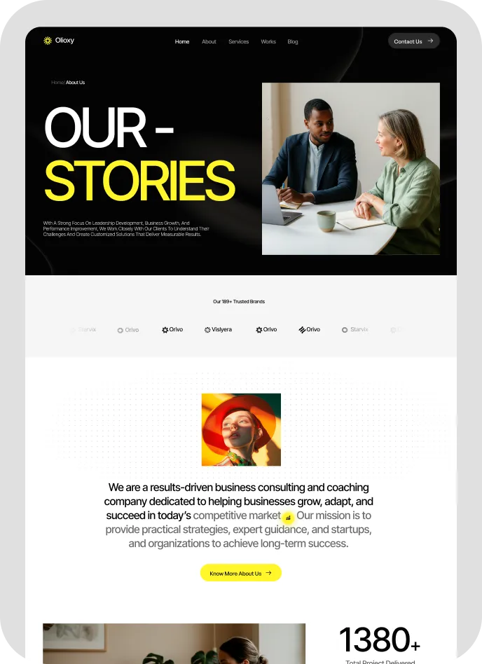 Website section titled 'Our Stories' with photo of two people having a business discussion at a table with laptop and documents.