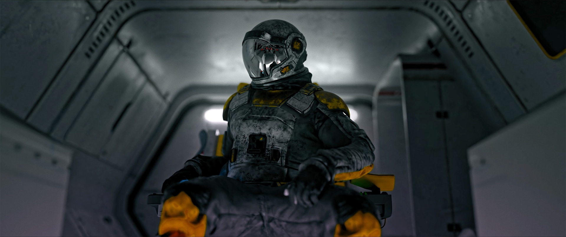 Astronaut in a worn yellow and gray spacesuit sitting inside a dimly lit spacecraft cabin.