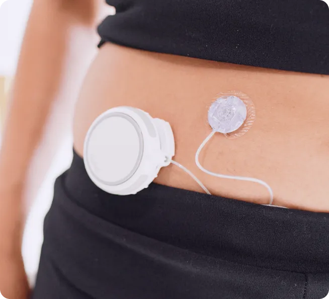 Person's abdomen with a wearable medical device and attached sensor patch connected by a thin wire.