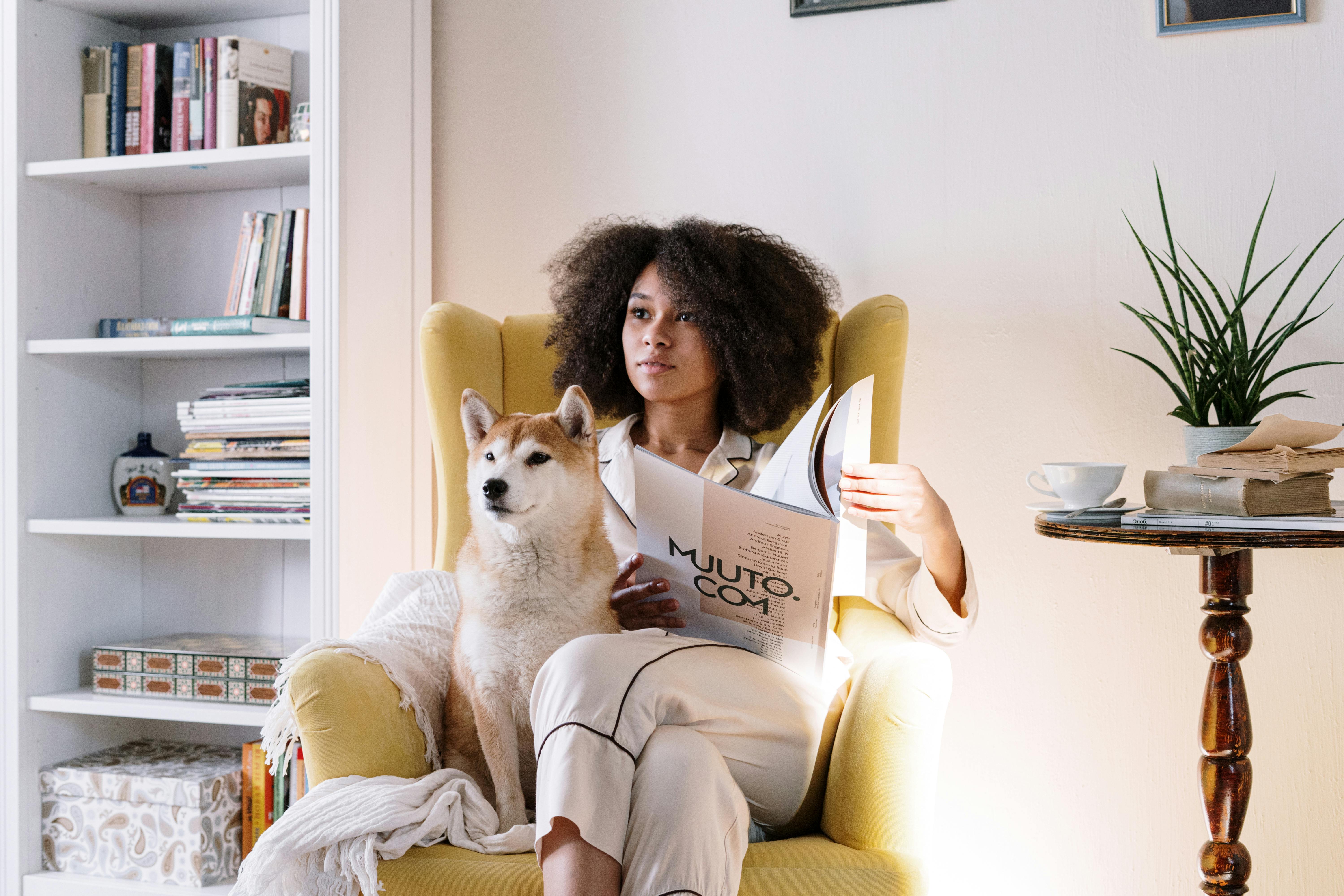 Woman with dog reading magazine stock image