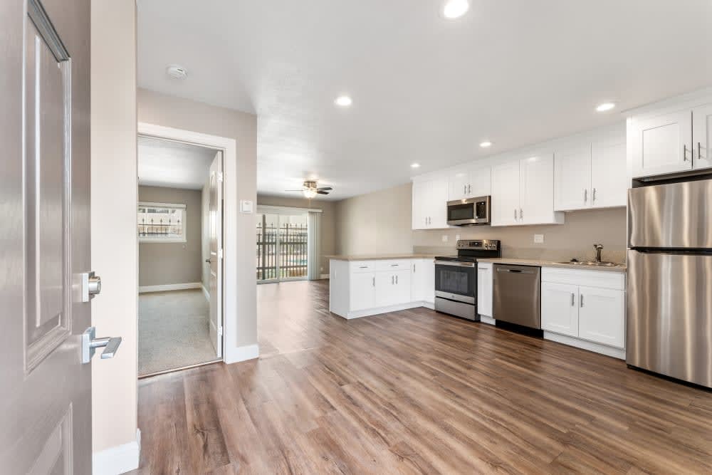 Wide view of unfurnished dining area and kitchen with stainless steel appliances