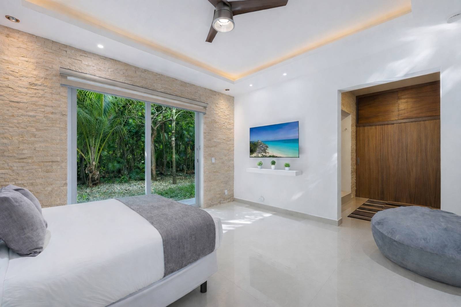 Luxury bedroom corner view with jungle-facing windows at Villa Hurakán