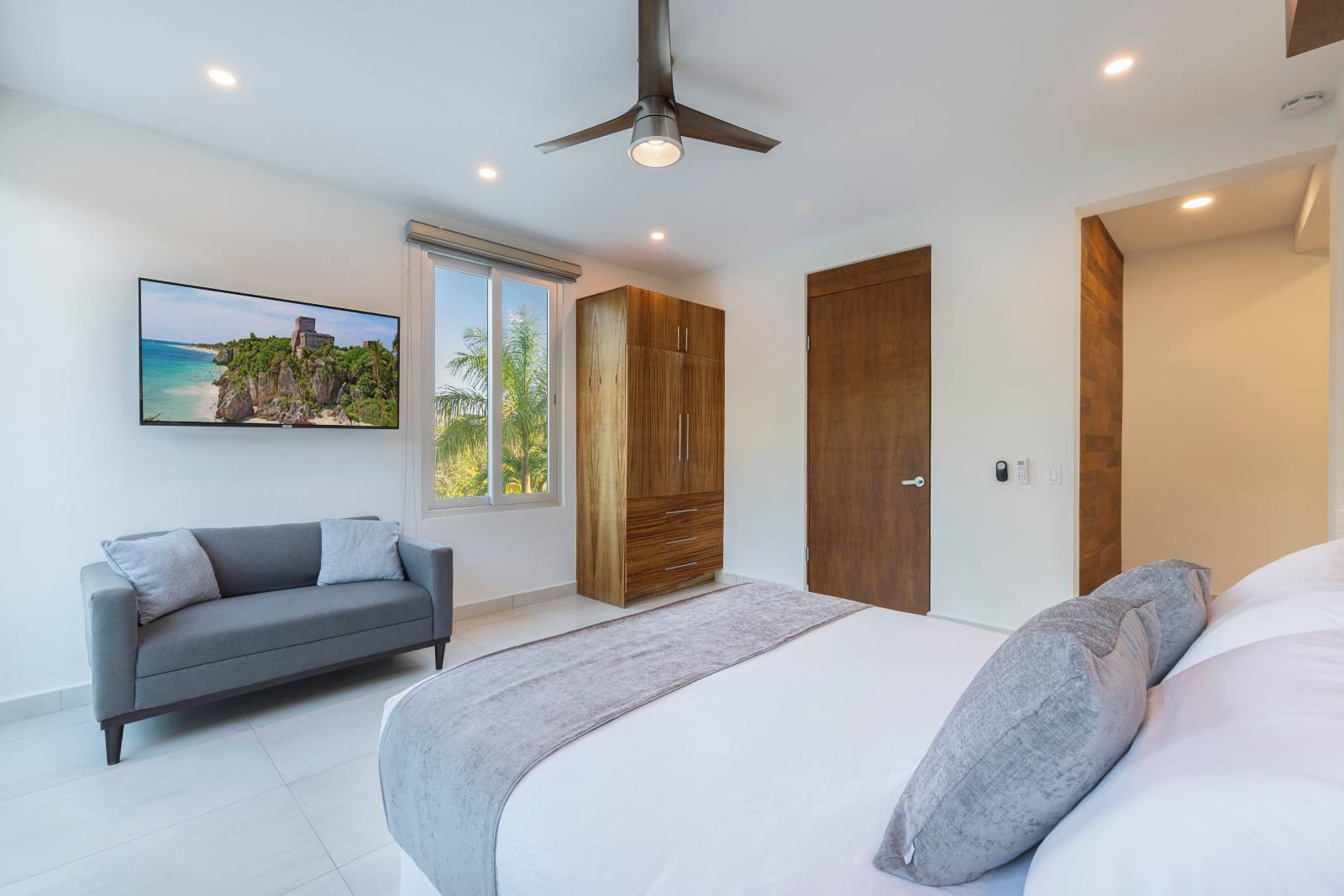 Spacious modern bedroom suite with lounge seating inside Villa Hurakán