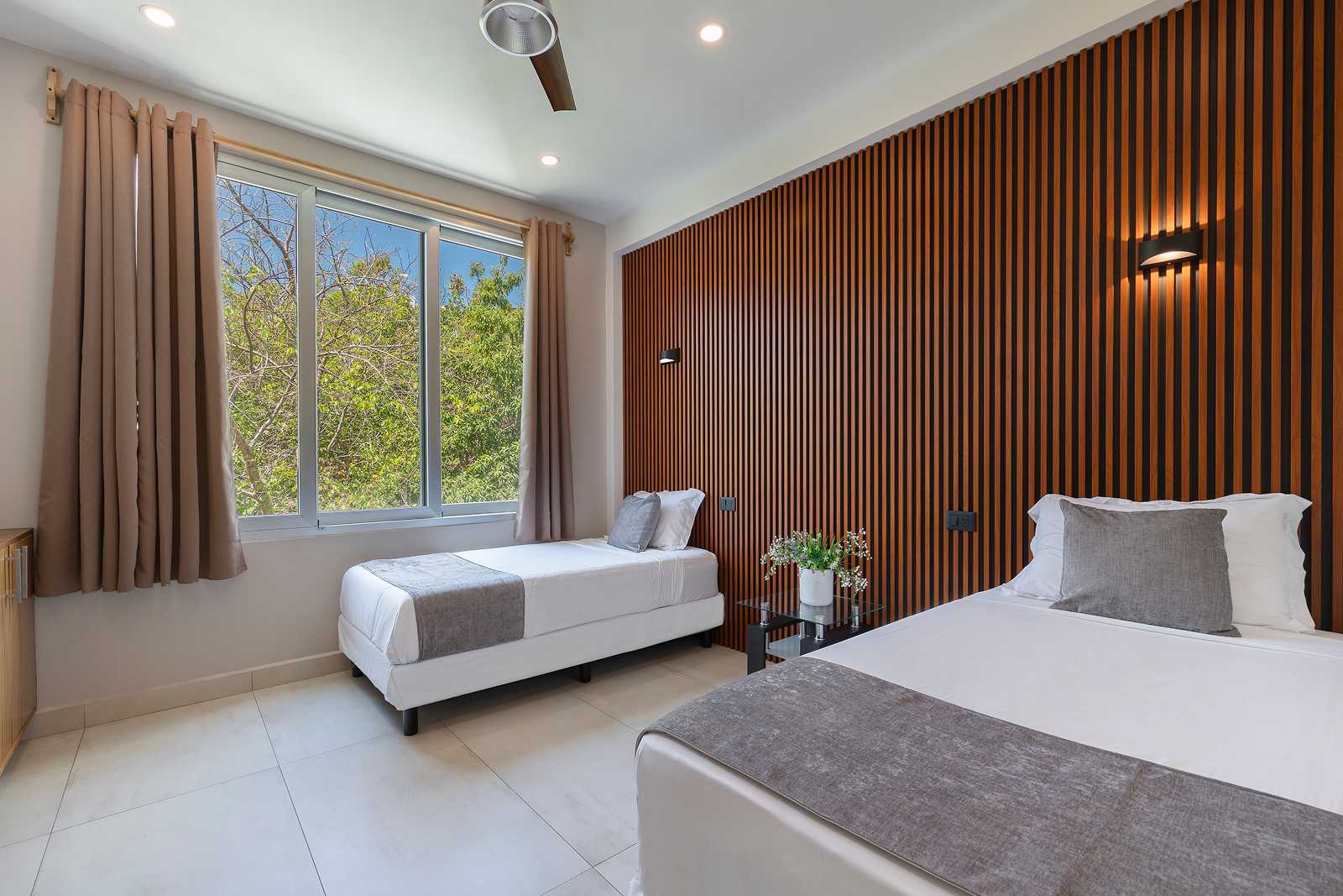 Guest bedroom with jungle-facing window inside Villa Hurakán luxury estate