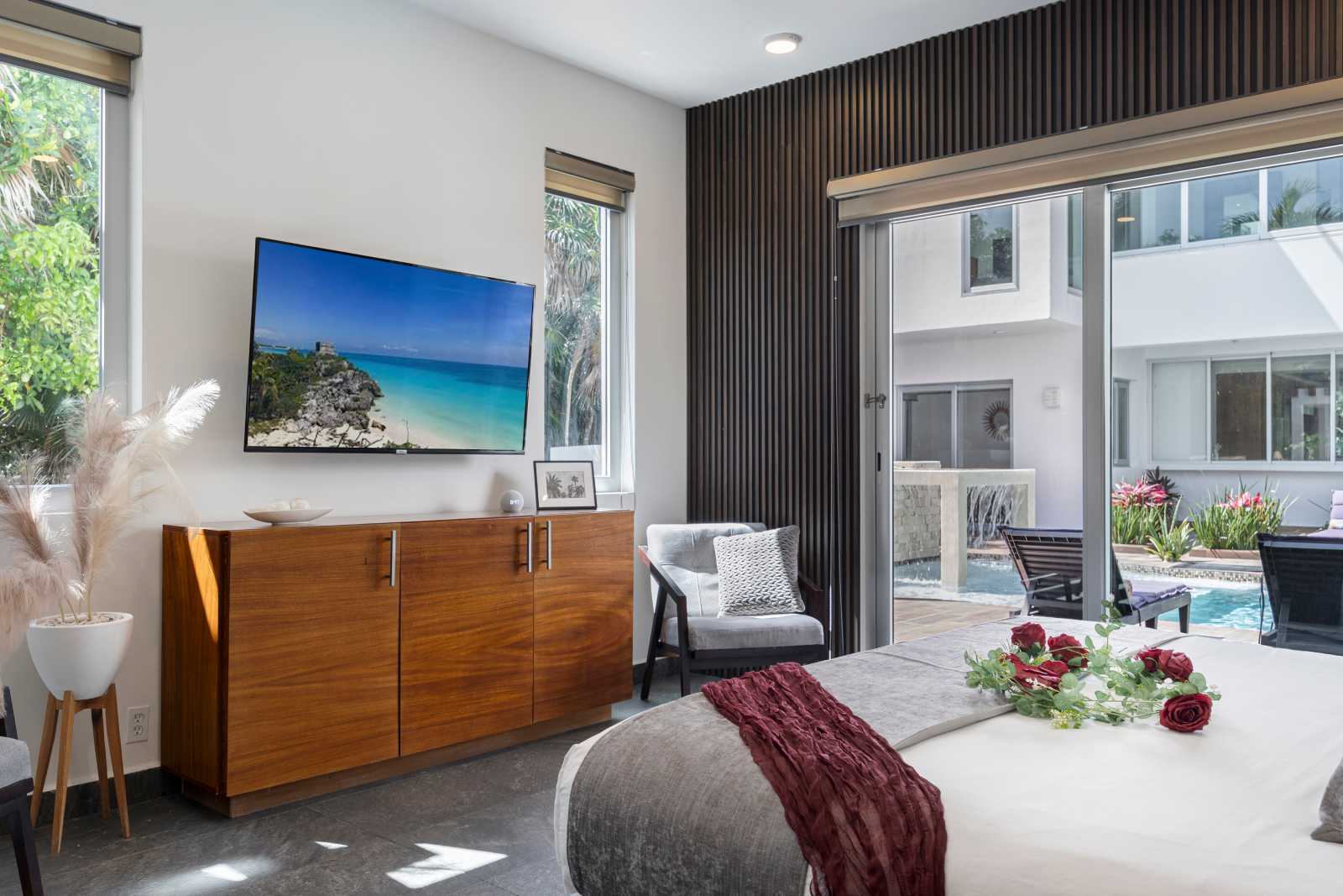 Luxury bedroom with balcony and pool-facing views at Villa Hurakán
