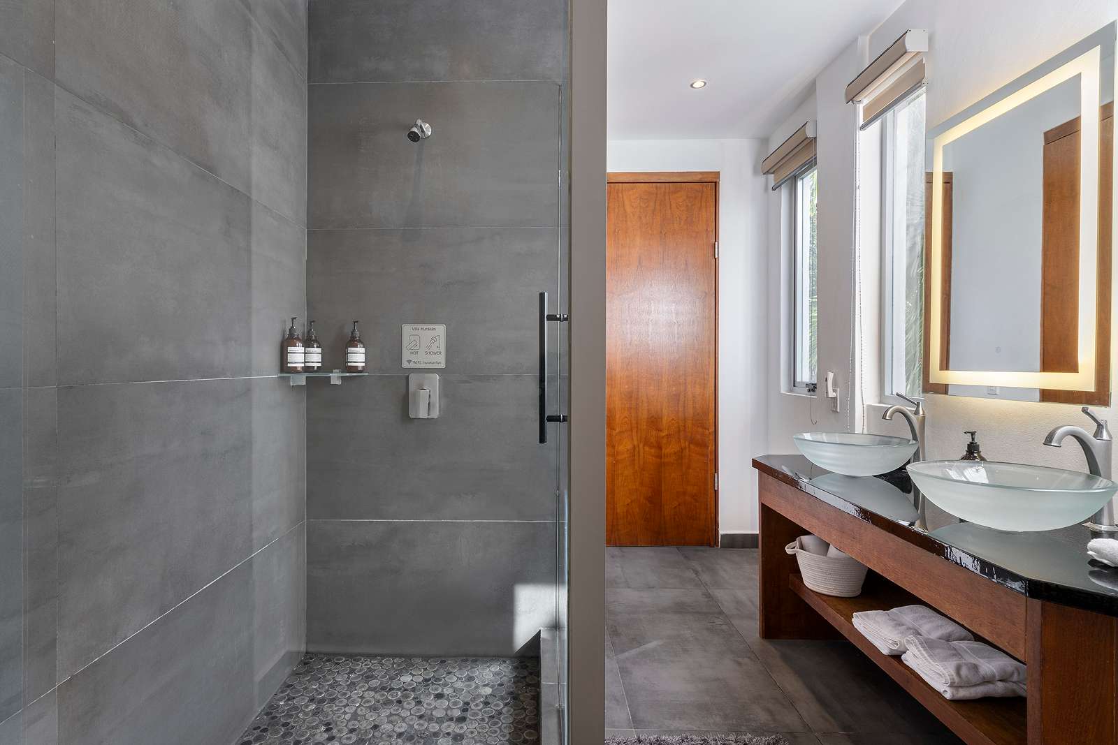 Modern stone-finish bathroom suite with double vanity at Villa Hurakán