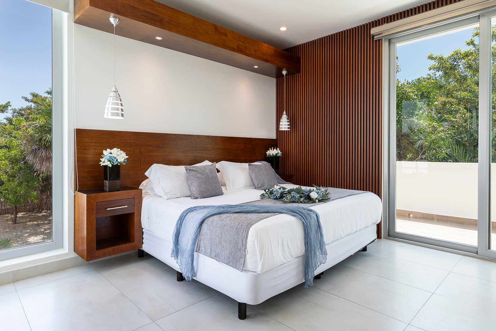 Bright luxury bedroom with corner windows at Villa Hurakán