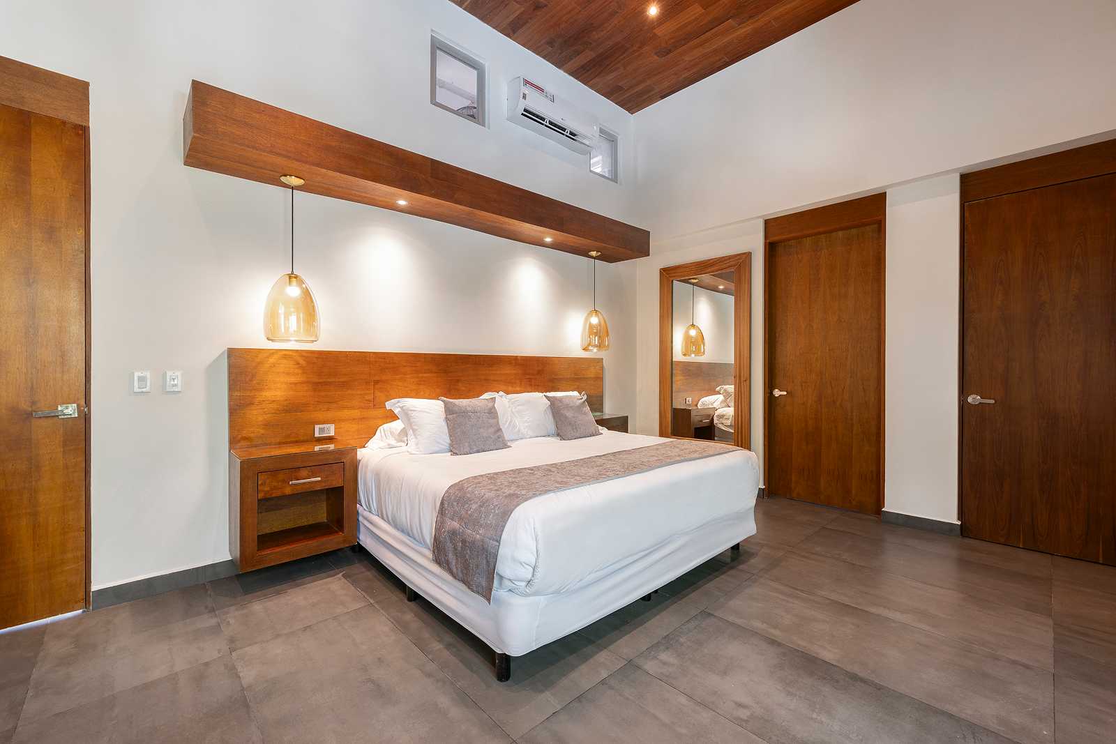 Modern luxury bedroom suite with vaulted ceiling at Villa Hurakán
