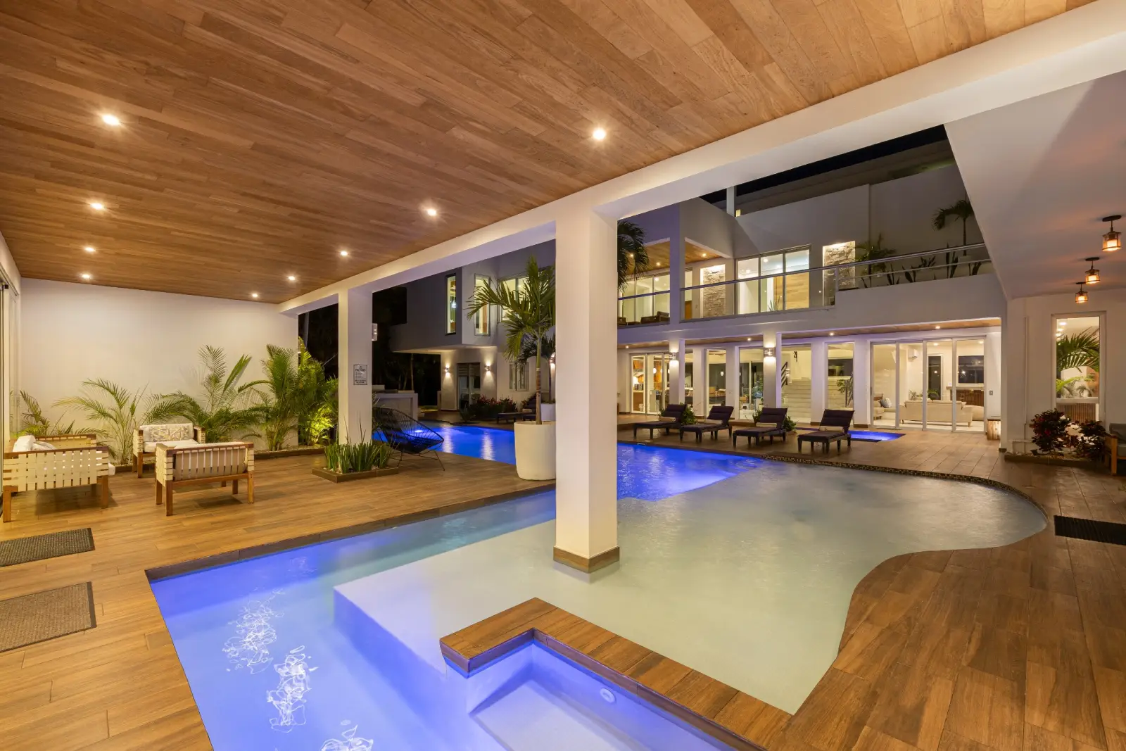 Illuminated central pool courtyard at night inside Villa Hurakán