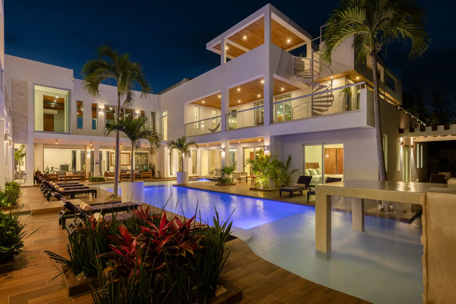 Luxury nighttime pool reflections and lounge atmosphere at Villa Hurakán