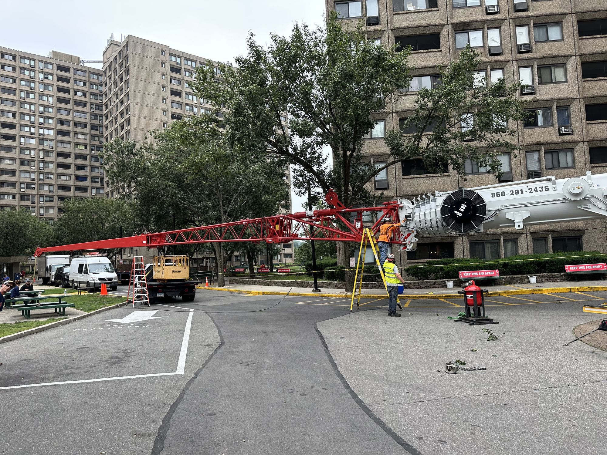 Operated crane reaching church steeple area with extended boom