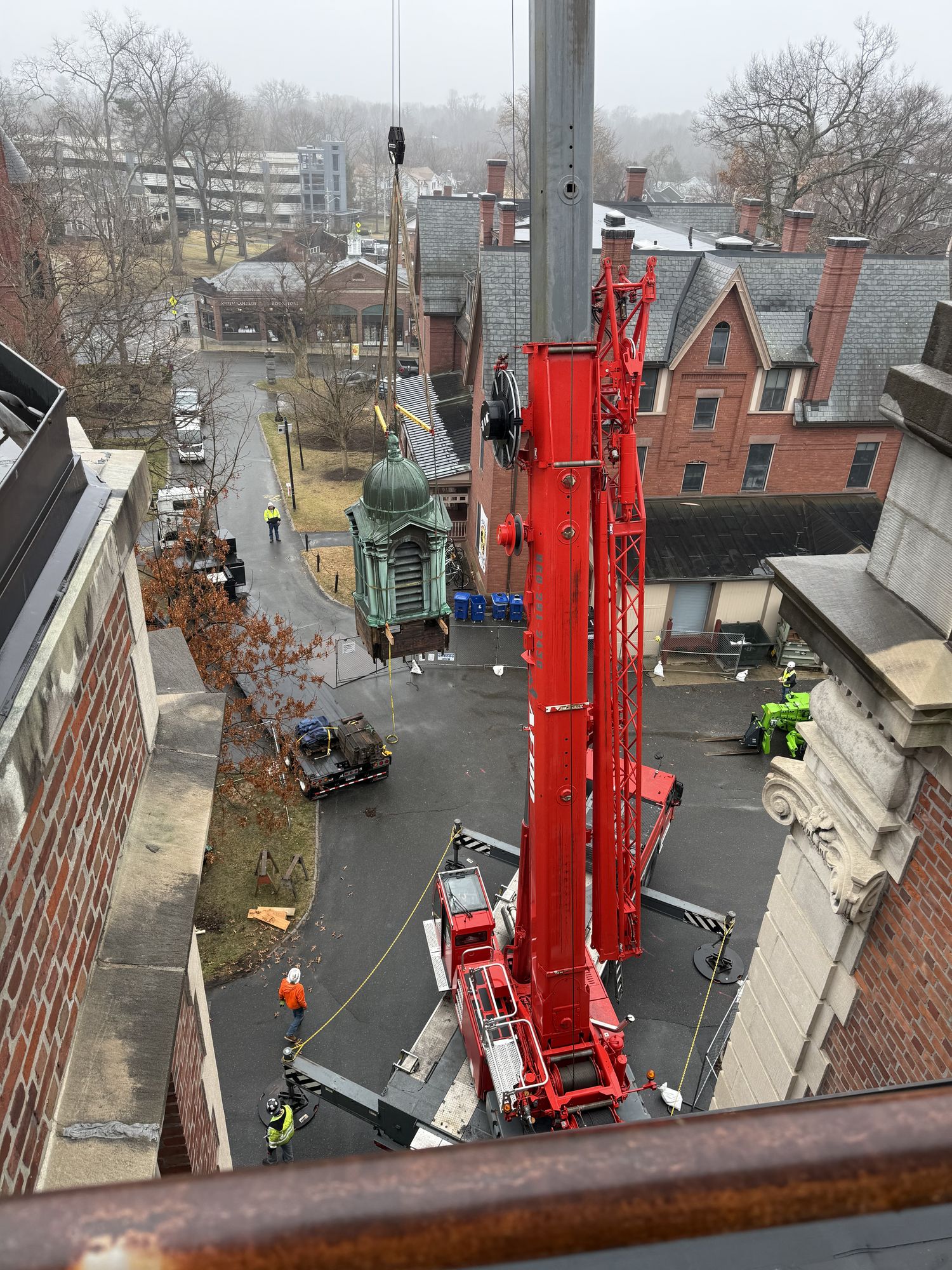 Aerial view of Aero red Liebherr crane removing church cupola